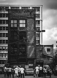grayscale photography of people standing in front of building thumbnail