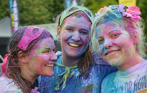 three woman enjoying Holi event during day time thumbnail