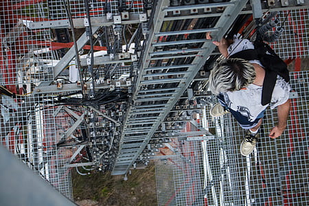 man looking on ground holding ladder thumbnail