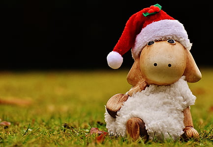 sheep wearing Santa hat sitting figurine on grass during day thumbnail