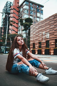 woman sitting in the middle of the road during daytime thumbnail
