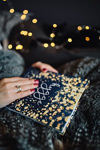 Young woman at home reading Hygge book and drinking thumbnail