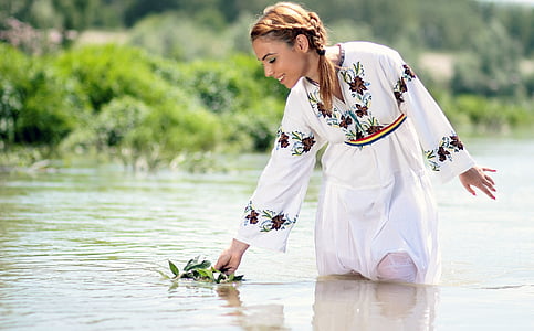 woman with white and brown floral dress in body of water at daytime thumbnail