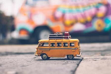 selective focus photography of yellow die-cast metal van on concrete floor thumbnail