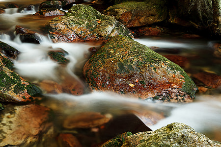 green-and-brown stones on body of water thumbnail
