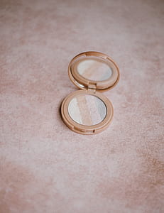round beige compact powder on beige surface thumbnail