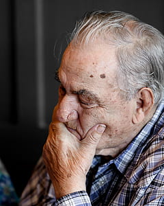 shallow focus photography of elderly man with his hand on mouth thumbnail