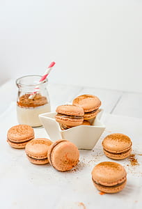 brown macaroons in white bowl beside jars thumbnail