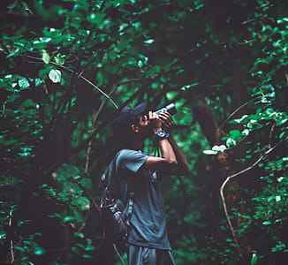 Man Standing Near Tree Taking Photo thumbnail