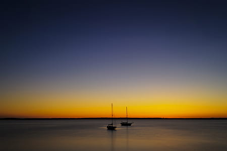 two sailboats on body of water during sunset thumbnail