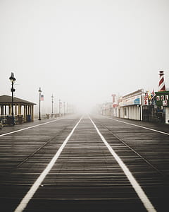 gray wooden pier with shops thumbnail