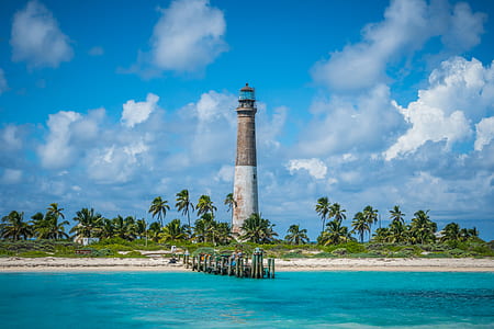 lighthouse on an island under blue sky during daytime thumbnail