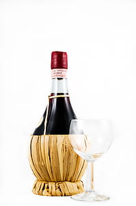 Clear Wine Glass Beside Red Wine Bottle thumbnail