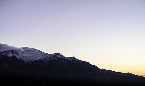 silhouette of mountain under white and yellow sky thumbnail