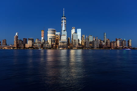 lighted building at night near body of water thumbnail