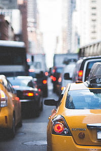 yellow Nissan Altima on road beside yellow vehicle at daytime thumbnail
