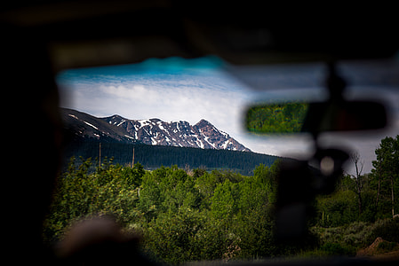 person riding vehicle near mountain at daytime thumbnail