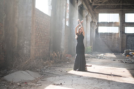 woman wearing black sleeveless dress raising her arms during daytime thumbnail