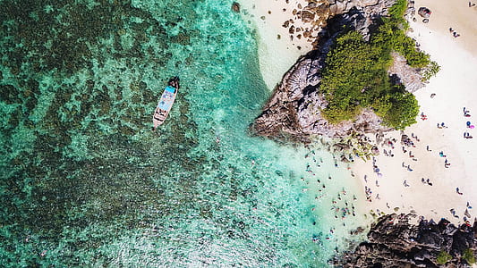 boat sailing on body of water near island thumbnail