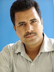 man in gray collared shirt with blue background on focus photo thumbnail