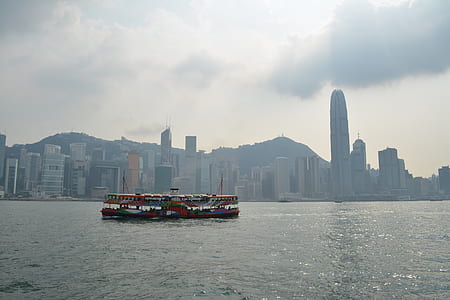 multicolored boat sailing on body of water during cloudy sky thumbnail