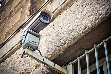 white bullet-type IP camera attached on gray grills thumbnail