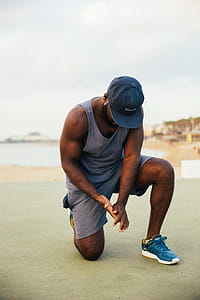 A young African man wearing casuals doing kneeling-workout outdoors thumbnail