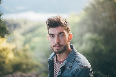 shallow focus photography of man standing near trees thumbnail