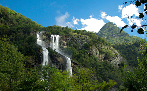 waterfalls near tree under white and blue sky during daytime photography thumbnail