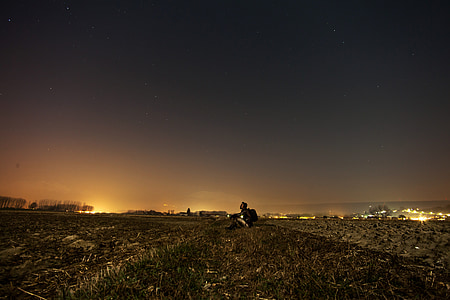 man sitting alone on field of grass thumbnail