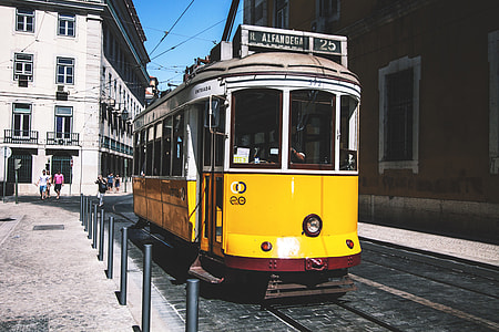 A yellow tram on the streets of Lisbon in Portugal thumbnail