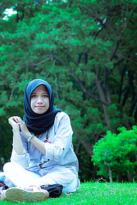 woman wearing black hijab headscarf sitting on green grass during daytime thumbnail