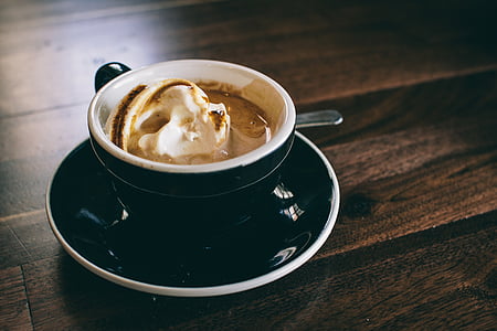 ice cream scoop in black ceramic cup on top of saucer thumbnail