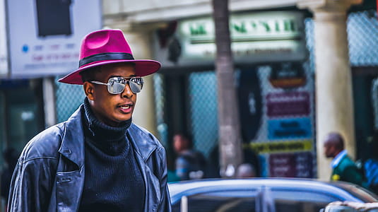 Man Wearing Purple Hat and Black Leather Jacket thumbnail