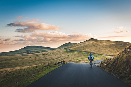 Cyclist with hills and clouds in the distance in Piatra Arsa, Romania thumbnail