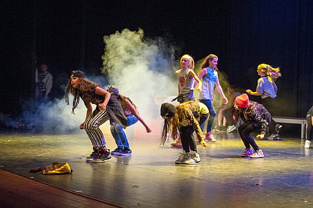 women dancing on stage with turned-off lights thumbnail