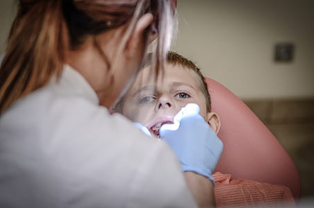 woman checking boy's mouth thumbnail