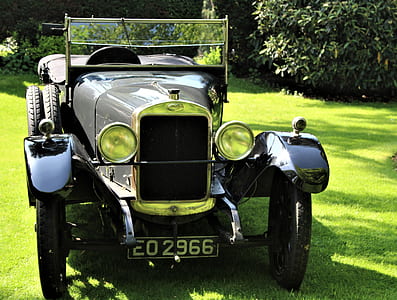 classic grey and black vehicle parked on green grass near trees thumbnail