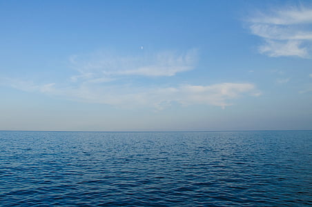 calm water overlooking horizon under cloudy sky at daytime thumbnail