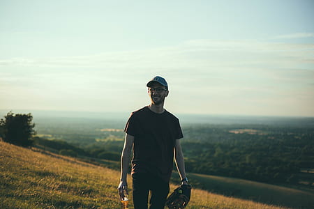 man standing on grenen grass field while holding baseball mitt thumbnail