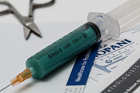green and clear syringe on white surface thumbnail