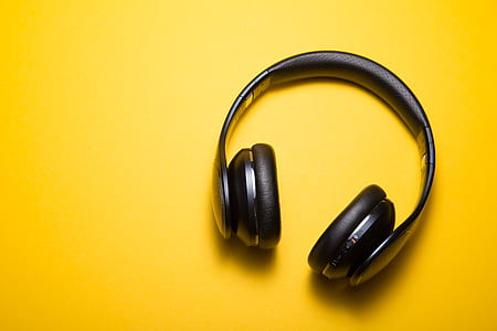 black Bluetooth headphones on yellow surface thumbnail