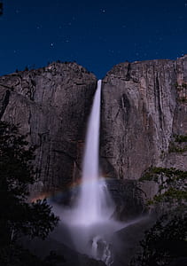 low angle photography of waterfalls at night thumbnail