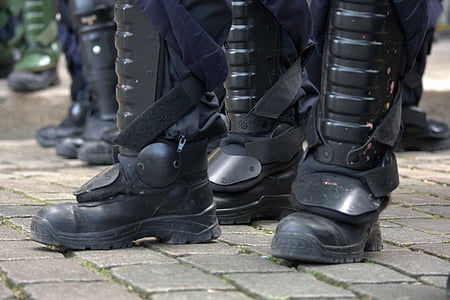 black leather combat boots on gray concrete pavement thumbnail