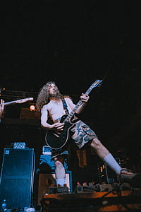 man playing electric guitar on stage thumbnail