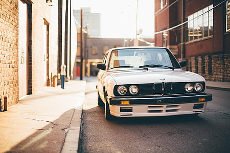 white BMW M3 E30 parked near concrete building during daytime thumbnail