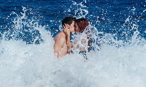 man and woman kissing on body of water thumbnail