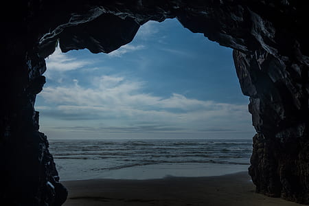 cave near body of water during daytime thumbnail