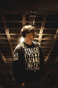 brunette haired man wearing backpack looking side view inside lighted room thumbnail