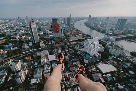 person on tower taking photo of aerial skyscraper at daytime thumbnail
